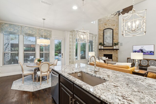 kitchen with white cabinetry, an island with sink, hanging light fixtures, custom range hood, and sink