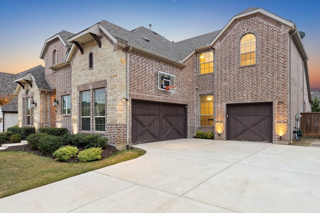 view of front of home with a garage, stone siding, and brick siding