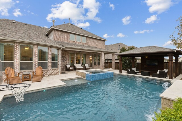 back house at dusk with a pool with hot tub, outdoor lounge area, and a patio