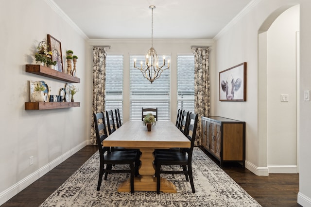 dining room with dark hardwood / wood-style flooring, crown molding, and a notable chandelier