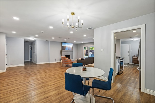 dining space featuring hardwood / wood-style flooring and a notable chandelier