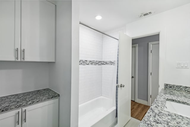 bathroom with vanity, tiled shower / bath, and hardwood / wood-style flooring