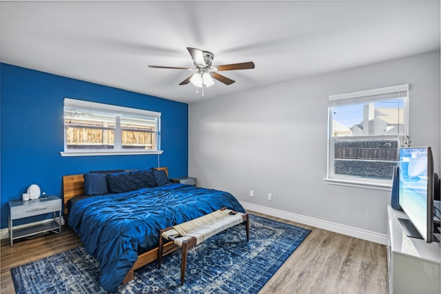 bedroom featuring multiple windows, ceiling fan, and dark hardwood / wood-style flooring