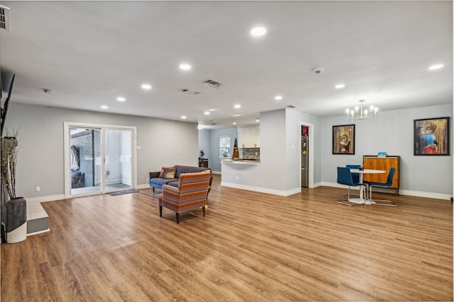 sitting room with light hardwood / wood-style floors and an inviting chandelier