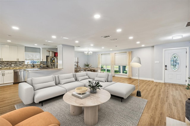 living room featuring sink and light hardwood / wood-style floors