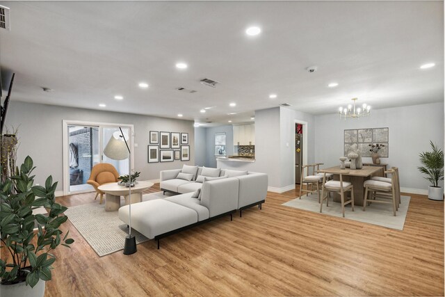 living room with light hardwood / wood-style flooring and a chandelier