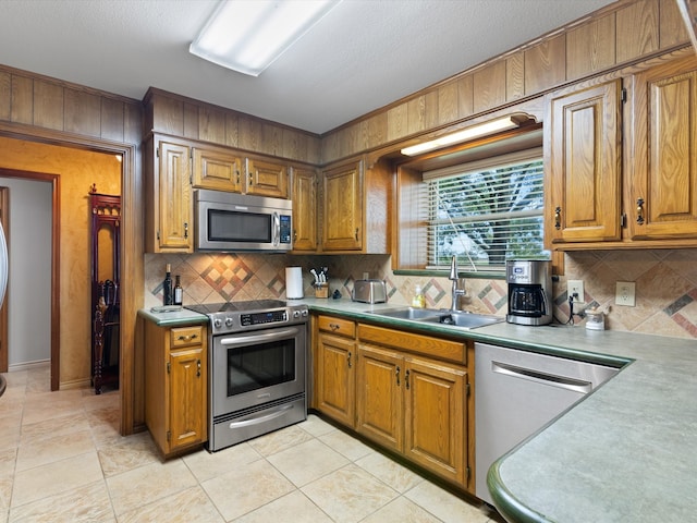 kitchen featuring tasteful backsplash, sink, light tile patterned flooring, and stainless steel appliances