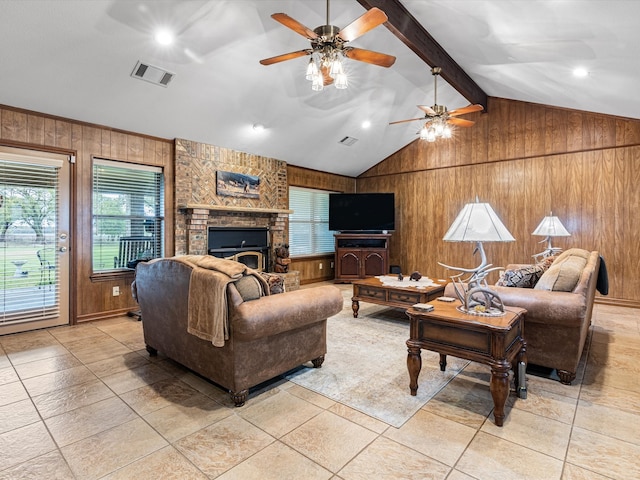 living room with a fireplace, lofted ceiling with beams, ceiling fan, and wood walls