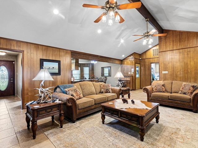 living room with lofted ceiling with beams, wood walls, and ceiling fan