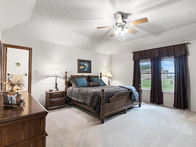 carpeted bedroom featuring vaulted ceiling, ceiling fan, and a textured ceiling