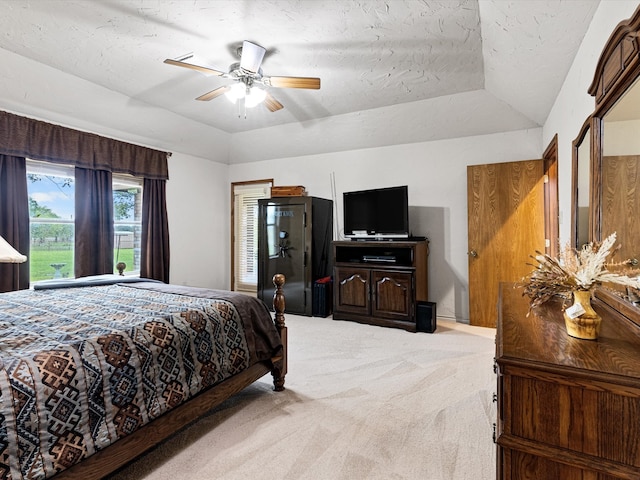 bedroom with a textured ceiling, ceiling fan, lofted ceiling, and light carpet