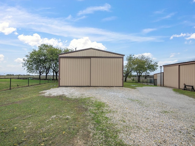 view of outdoor structure with a rural view and a yard