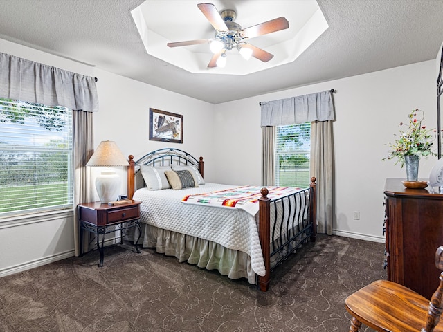 bedroom featuring multiple windows, ceiling fan, and dark carpet