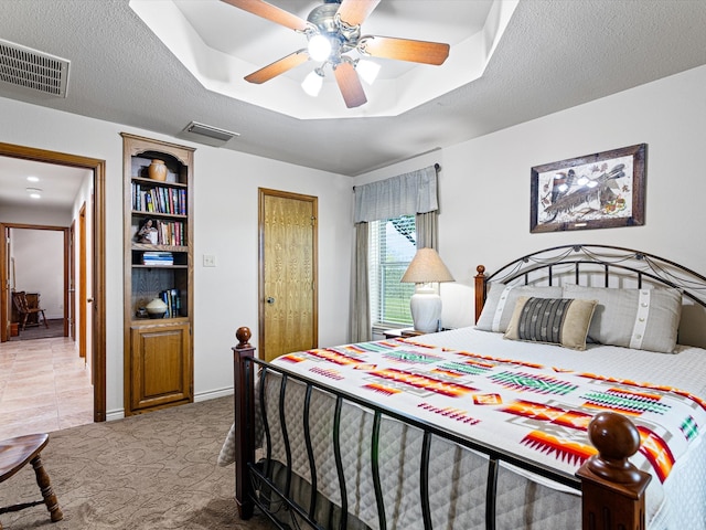 bedroom featuring tile patterned floors, ceiling fan, and a textured ceiling