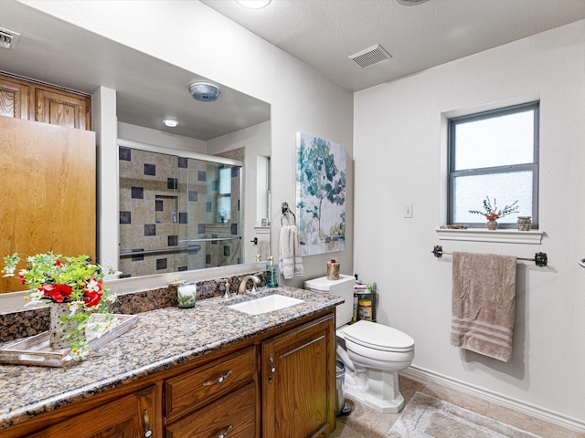 bathroom with tile patterned floors, a textured ceiling, vanity, a shower with door, and toilet