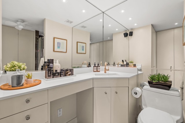 bathroom featuring vanity, ceiling fan, toilet, and walk in shower