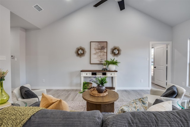 living room with light hardwood / wood-style floors, ceiling fan, and lofted ceiling