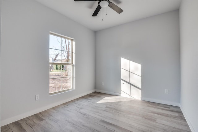 unfurnished room featuring light wood-type flooring, baseboards, and a ceiling fan