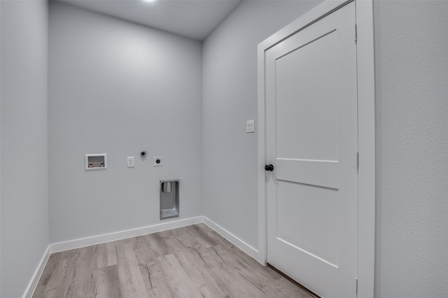 clothes washing area featuring hookup for a washing machine, hookup for an electric dryer, laundry area, baseboards, and light wood finished floors