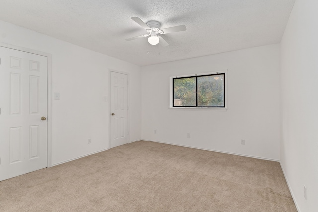 unfurnished room featuring light carpet, a textured ceiling, and ceiling fan