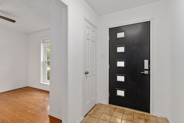 foyer with a textured ceiling and light hardwood / wood-style flooring