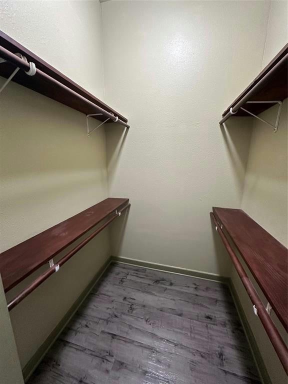 spacious closet with dark wood-type flooring