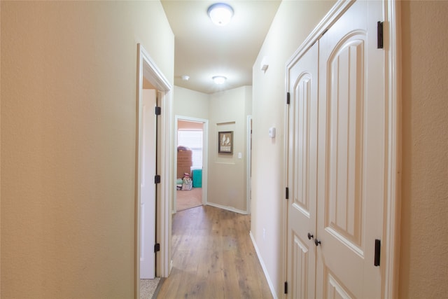 hallway with light hardwood / wood-style floors