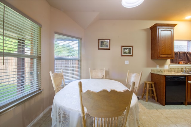 dining area with light tile patterned floors and vaulted ceiling