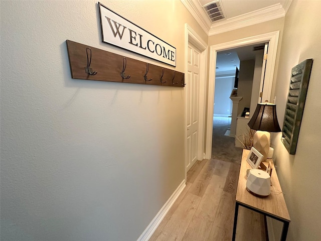 hall featuring ornamental molding and light hardwood / wood-style floors