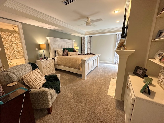 carpeted bedroom featuring a tray ceiling, connected bathroom, ceiling fan, and ornamental molding