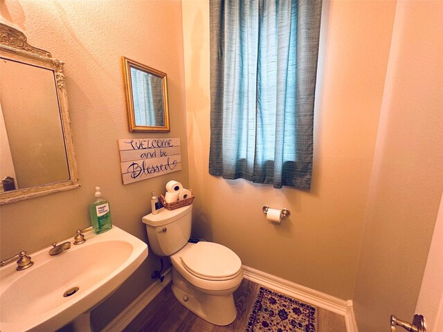 bathroom featuring hardwood / wood-style flooring, toilet, and sink