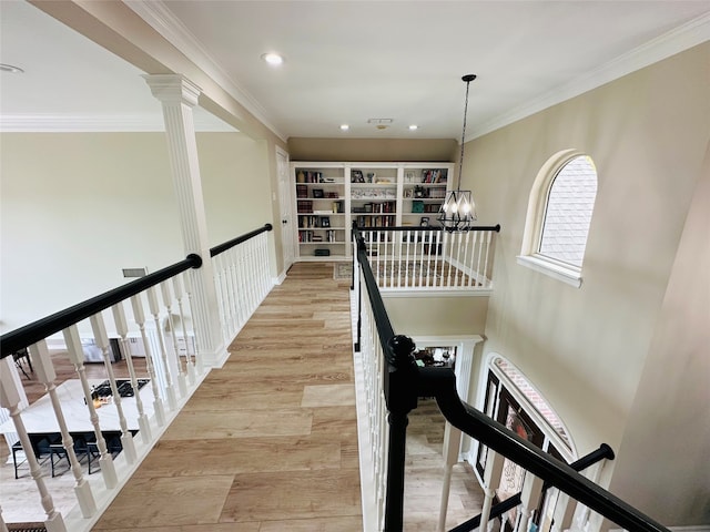 stairway with hardwood / wood-style floors, ornamental molding, and an inviting chandelier