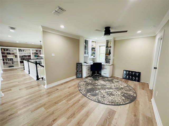 home office featuring ornamental molding, built in desk, ceiling fan, and light hardwood / wood-style flooring