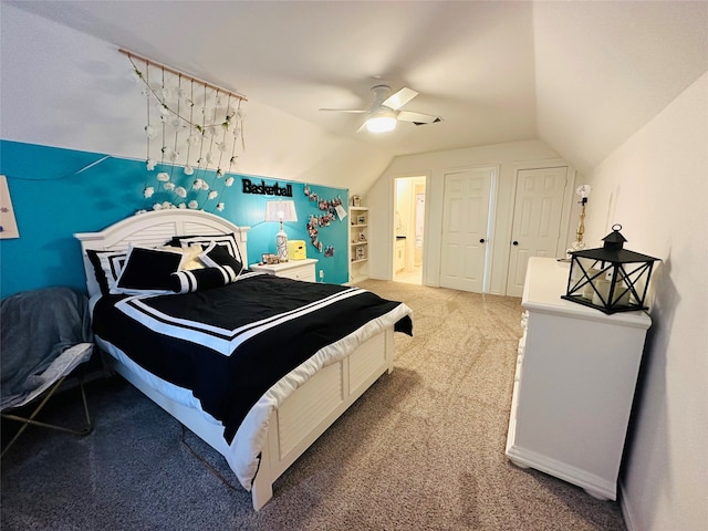 bedroom featuring carpet, ensuite bathroom, ceiling fan, and lofted ceiling