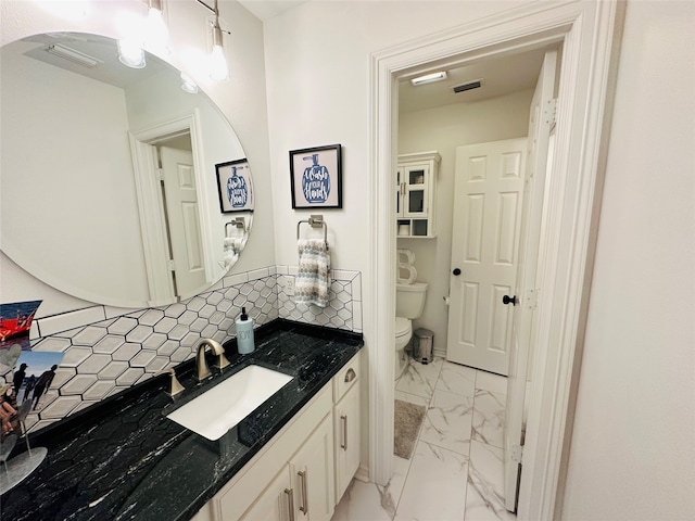 bathroom featuring decorative backsplash, vanity, and toilet