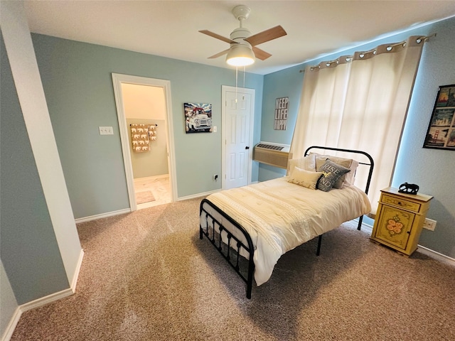 carpeted bedroom with ceiling fan, an AC wall unit, and ensuite bath