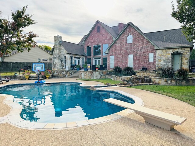 view of pool featuring a patio area and a diving board