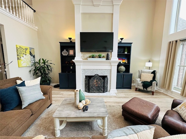 living room with plenty of natural light, light hardwood / wood-style floors, and a high ceiling