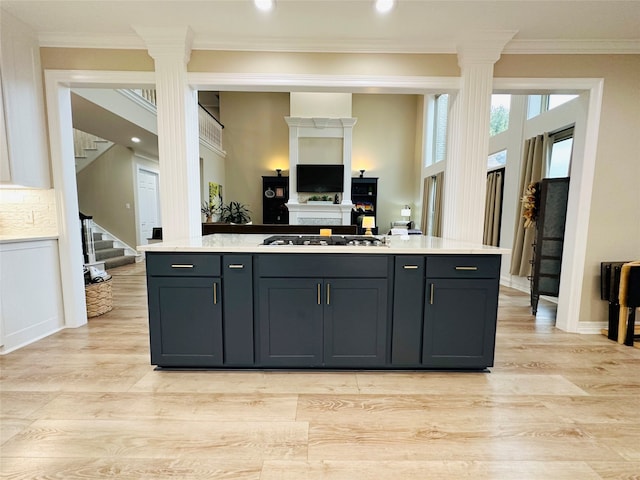 kitchen with gas stovetop, crown molding, gray cabinetry, and light hardwood / wood-style floors