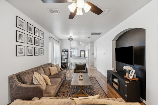 living room with wood-type flooring and ceiling fan