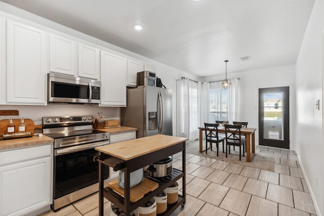 kitchen with white cabinetry, an inviting chandelier, pendant lighting, and appliances with stainless steel finishes