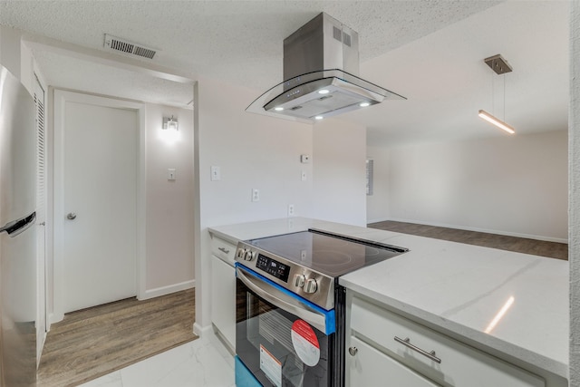 kitchen featuring island exhaust hood, a textured ceiling, stainless steel appliances, decorative light fixtures, and white cabinets