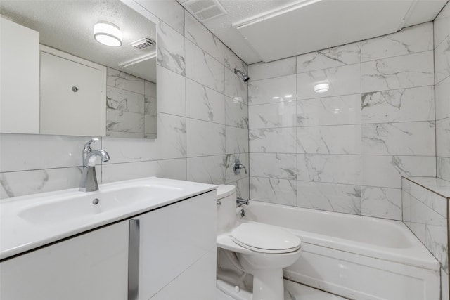 full bathroom featuring shower / bath combination, vanity, a textured ceiling, tile walls, and toilet