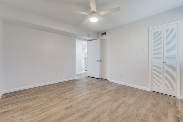 unfurnished bedroom with a closet, light hardwood / wood-style floors, and ceiling fan