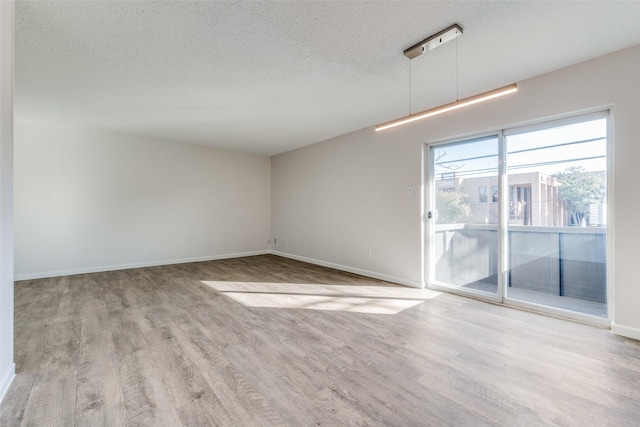 empty room featuring light hardwood / wood-style flooring and a textured ceiling