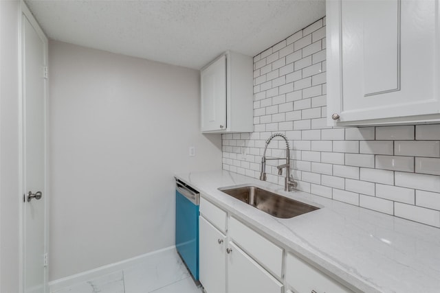 kitchen featuring decorative backsplash, white cabinetry, and sink