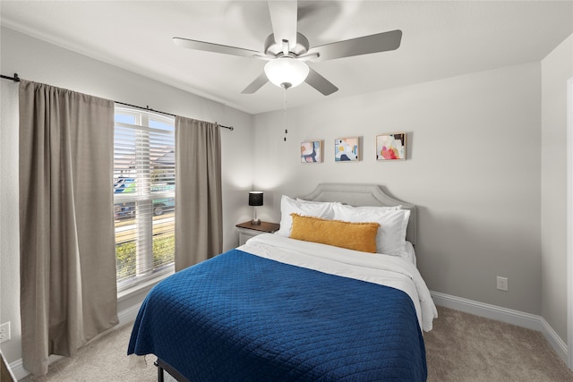 bedroom featuring ceiling fan, carpet floors, and multiple windows