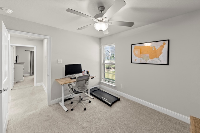 office space with ceiling fan and light carpet