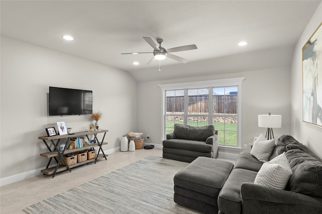 living room with ceiling fan, light tile patterned floors, and vaulted ceiling