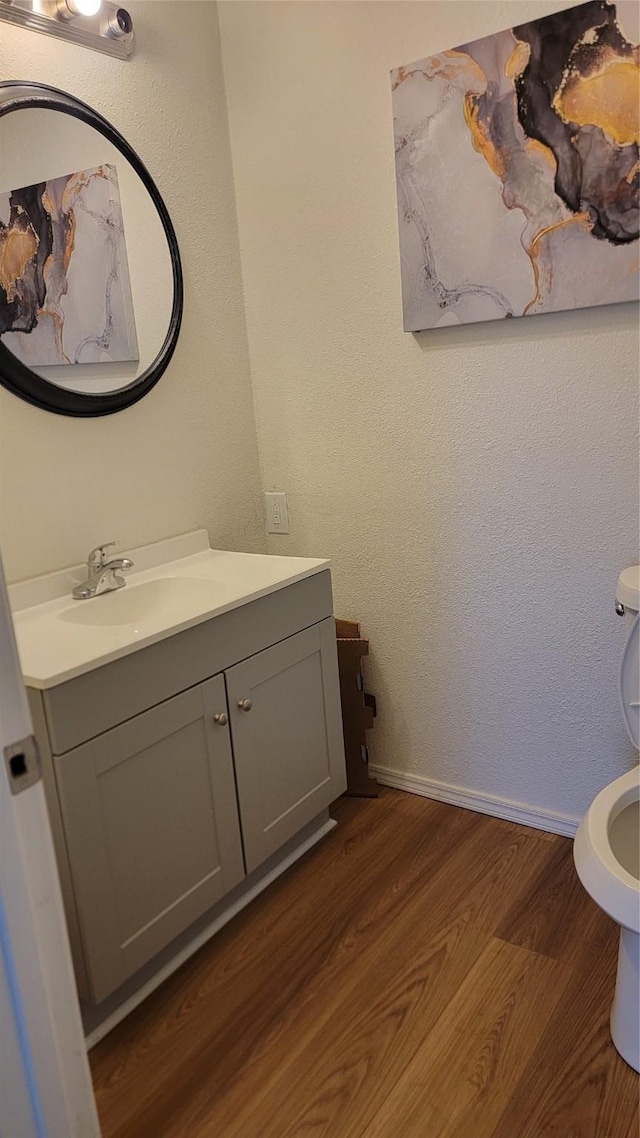 2001 Alma, Sherman, TX 75090 - half bath featuring toilet, vanity, wood finished floors, and baseboards